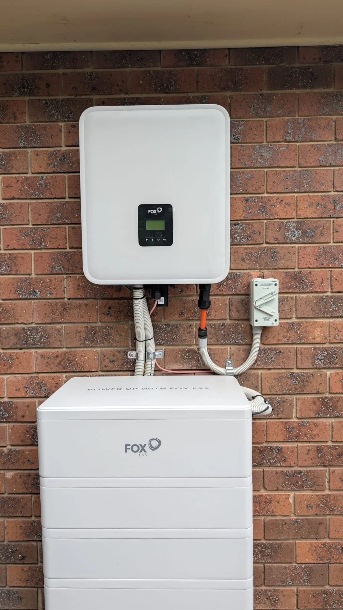 Fox ESS hybrid inverter and stacked battery installed on a brick wall at a Melbourne home